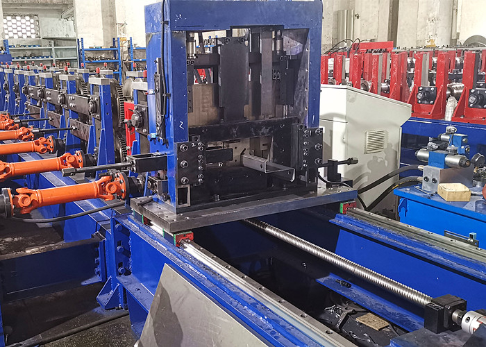 A detail shot of a multi-functional flying cutting device integrated into a roll forming machine, shown with shaped metal passing through it, ready for precision cuts.